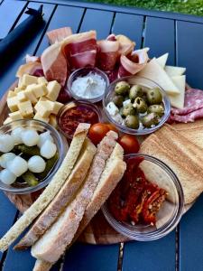 ein Tablett mit Käse, Brot und anderen Lebensmitteln in der Unterkunft La bulle du Bon'Heure in Somme-Leuze