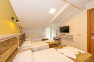 a hotel room with four beds and a flat screen tv at Bazaar Hotels Old City in Istanbul