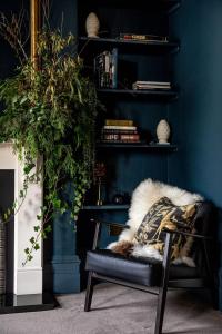 謝伯恩的住宿－The Townhouse Sherborne，一间设有蓝色墙壁、椅子和植物的房间
