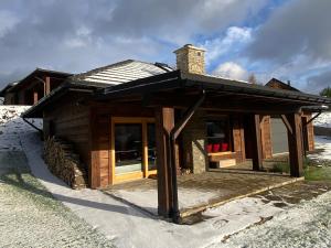 a small log cabin with a chimney on top at Bielańska Ostoja in Uście Gorlickie