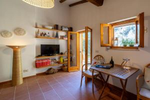 uma sala de estar com uma mesa e uma televisão em Villetta indipendente sul Mare em Monte Argentario