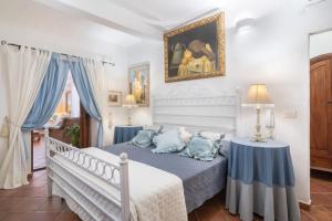 una camera da letto con letto e cuscini blu di Domus Siracleto Villa, Notteri, Porto Giunco, pool a Notteri