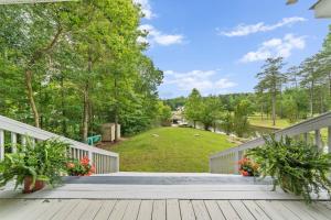 a large deck with two potted plants and a yard at Lake Sinclair in Eatonton