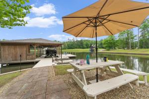 a picnic table with an umbrella next to a lake at Lake Sinclair in Eatonton