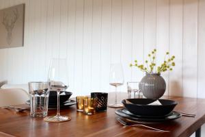 - une table en bois avec des verres à vin et un vase dans l'établissement Ferienhaus am Reiterhof, à Wernigerode 14 autres photos