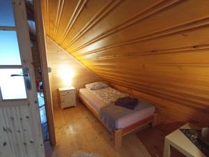 Dormitorio pequeño con cama en el techo de madera en U Krysi, en Kojszówka