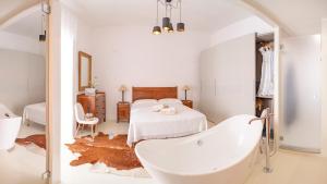 a white bathroom with a tub and a bed at Casa Salvi Positano in Positano