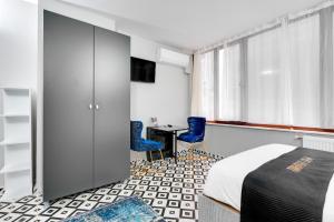 ein Schlafzimmer mit einem Bett und zwei blauen Stühlen in der Unterkunft Portist Hotel in Istanbul