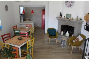 a living room with tables and chairs and a fireplace at La Petite Famille in Corchiano