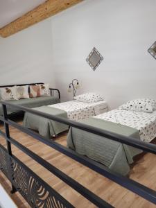 twee bedden in een kamer met witte muren bij Pissenlit Une Prairie en Provence in Arles