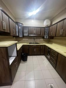 an empty kitchen with wooden cabinets and a sink at 8 Luxury housing شقة فاخر in Al ‘Awālī