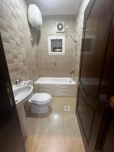 La salle de bains est pourvue de toilettes, d'une baignoire et d'un lavabo. dans l'établissement 8 Luxury housing شقة فاخر, à Médine