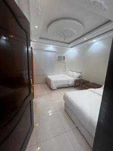 a hotel room with two beds and a table at 8 Luxury housing شقة فاخر in Al ‘Awālī