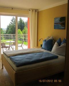 Schlafzimmer mit einem großen Bett und einem Balkon in der Unterkunft Ferien im Maigen in Tünsdorf