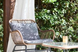 una sedia di vimini con cuscino seduta accanto a un tavolo di Vuvulà a Francavilla al Mare