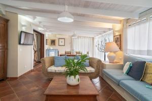 un soggiorno con divano e tavolo di Domus Siracleto Villa, Notteri, Porto Giunco, pool a Notteri