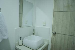 a white bathroom with a toilet and a mirror at COLIBRI Gorgeous new flat with balcony and terrace in Cali