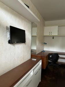 a room with a desk and a tv on the wall at Espaço Casa in Campina Grande