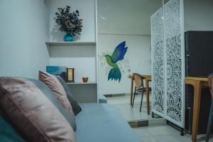 a living room with a couch and a bird on the wall at COLIBRI Gorgeous new flat with balcony and terrace in Cali
