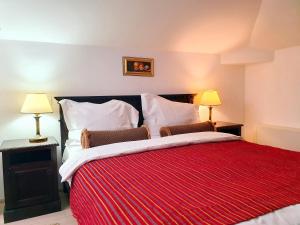 1 dormitorio con 1 cama grande con manta roja en Vila Leonida - RESORT LEONIDA en Buşteni