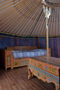 "Verdon Yourtes" Camping à la ferme في Angles: غرفة نوم مع سريرين في يورت