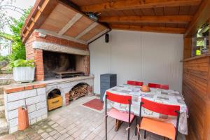 a patio with a table and a fireplace at Apartment Sirol in Labin