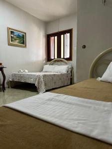 a bedroom with two beds and a window at Espaço Casa in Campina Grande