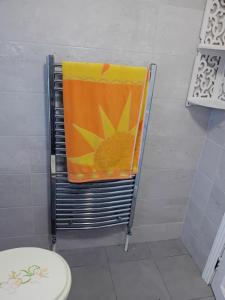 - une serviette orange sur un porte-serviettes dans la salle de bains dans l'établissement 56 lower mount carmel, à New Ross