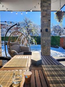a wooden table and bench on a patio with snow at Къща за гости Vip House 