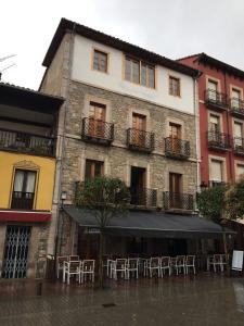 un edificio con mesas y sillas bajo la lluvia en Pensión San Pelayo 10 en Cangas de Onís