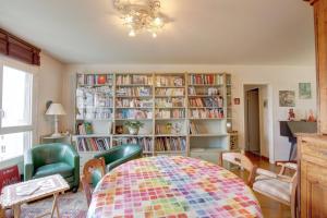 una stanza con tavolo e librerie con libri di Aux Portes des Lilas a Bagnolet