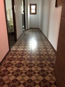 um corredor com piso em azulejo num quarto em Pensión San Pelayo 10 em Cangas de Onís