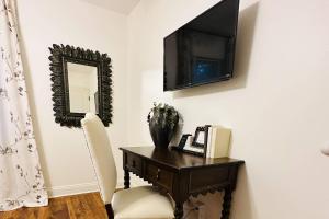 a room with a desk with a television and a chair at Discover Decatur in Decatur