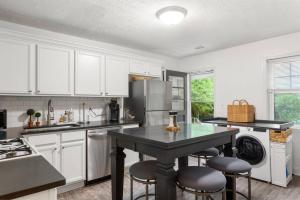 een keuken met witte kasten en een tafel met krukken bij Discover Decatur in Decatur
