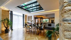 una sala da pranzo e una cucina con soffitto in vetro di La Maison d'Ernest - Climatisée - Circuit DIJON PRENOIS a Prenois