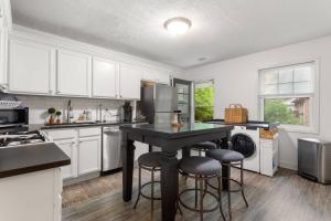 a kitchen with white cabinets and a black island with bar stools at Discover Decatur in Decatur
