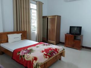 1 dormitorio con 1 cama y TV. en Khách sạn Việt Hoàng, en Bảo Lạc