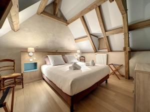 ein Schlafzimmer mit einem großen Bett und einem Stuhl in der Unterkunft Ty Breignou Coz superbe demeure bretonne in Bourg-Blanc