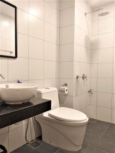 uma casa de banho branca com um WC e um lavatório em Chambers PWTC By GrandRoyal em Kuala Lumpur
