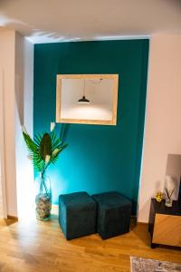 a living room with a blue wall and a plant at Apartman Besta in Banja Luka