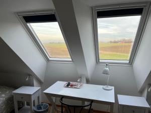 Habitación con 2 ventanas y mesa blanca. en Hobykrok B&B, en Lund