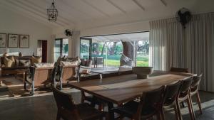 sala de estar con mesa de madera y sillas en Kolokolo Safari Home en Lentswelemoriti