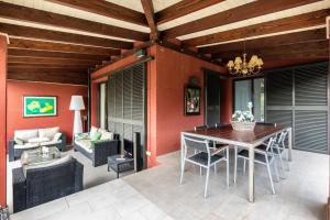 eine Terrasse mit einer Holzdecke sowie einem Tisch und Stühlen in der Unterkunft Villa Marimar - Private Pool in Bonmont Terres Noves