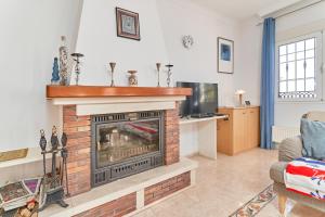 a living room with a fireplace and a tv at Villa Thomas in Frigiliana