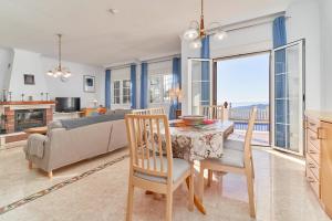 a kitchen and living room with a table and a couch at Villa Thomas in Frigiliana