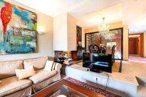 ein Wohnzimmer mit einem Sofa und einem TV in der Unterkunft Villa Marimar - Private Pool in Bonmont Terres Noves