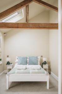 a bedroom with a white bed with blue pillows at The Old Granary in Barnetby le Wold
