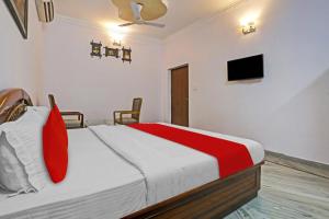 a bedroom with a bed and a tv on the wall at OYO Flagship Premium rooms in New Delhi