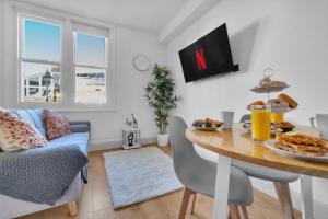 homely - West London Apartments Putney في لندن: غرفة معيشة مع طاولة عليها طعام