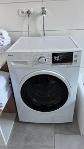 a white washing machine sitting in a kitchen at Große COZY 3-Zi-Whg mit Balkon Nähe Europa Park und Rulantica in Lahr